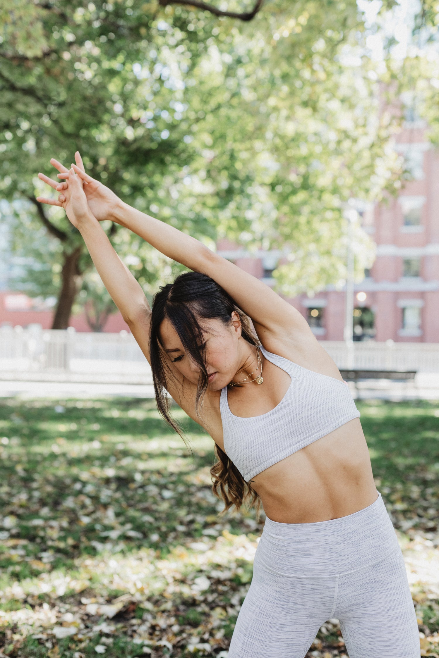 Young woman stretching in a park for wellness and flexibility, supporting an active lifestyle